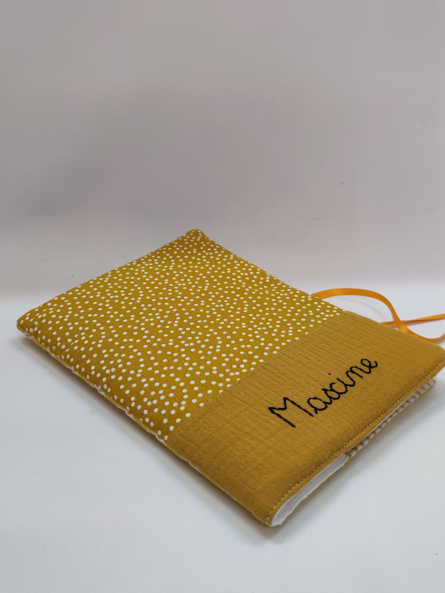 Prénom brodé en noir sur une housse de carnet de santé moutarde, personnalisation artisanale et graphique, Marinette Machin chouette