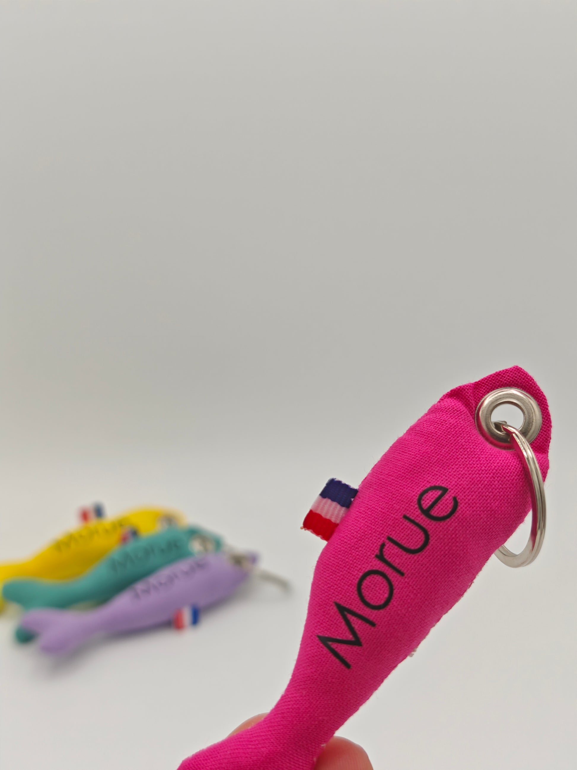 Porte-clé sardine en tissu rose flashy avec message 'Morue' floqué, création artisanale faite main.