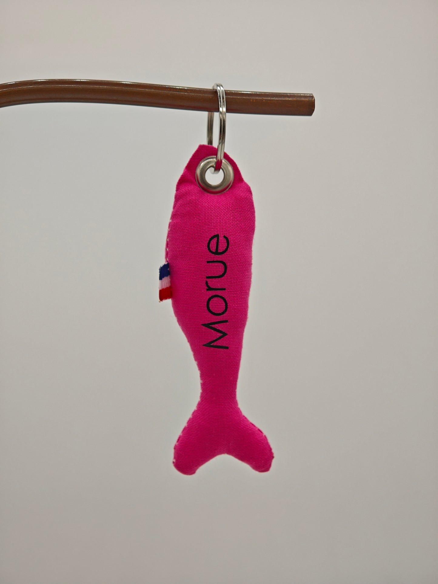 Porte-clé sardine en tissu rose flashy avec message 'Morue' floqué, création artisanale faite main.