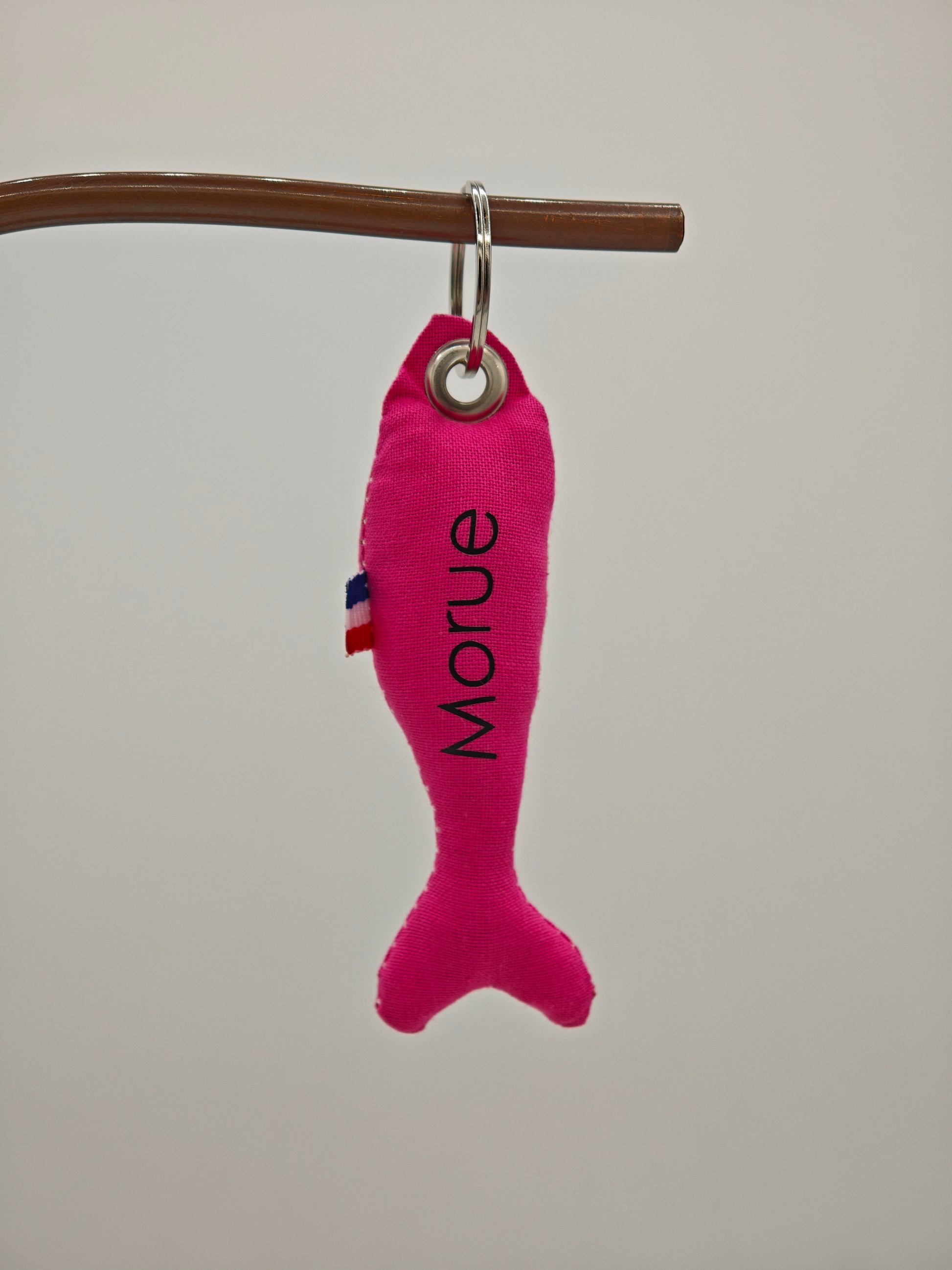 Porte-clé sardine en tissu rose flashy avec message 'Morue' floqué, création artisanale faite main.